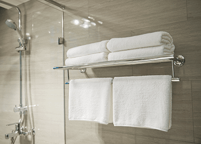 White towels on towel hanger shelf in bathroom