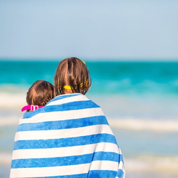 Two young children wrapped in blue California Cabana Towels