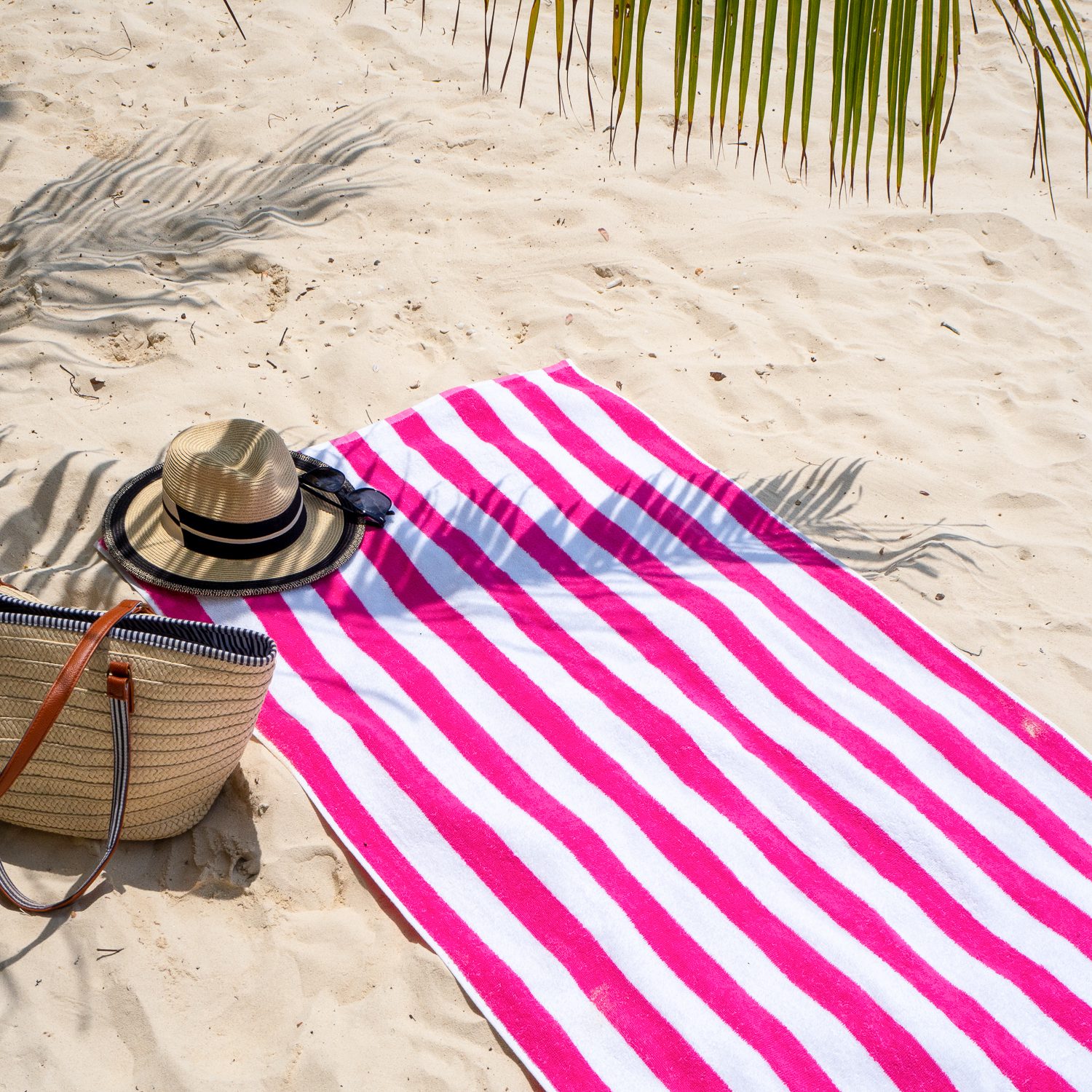 Pink Cabana Beach Towel on sandy beach