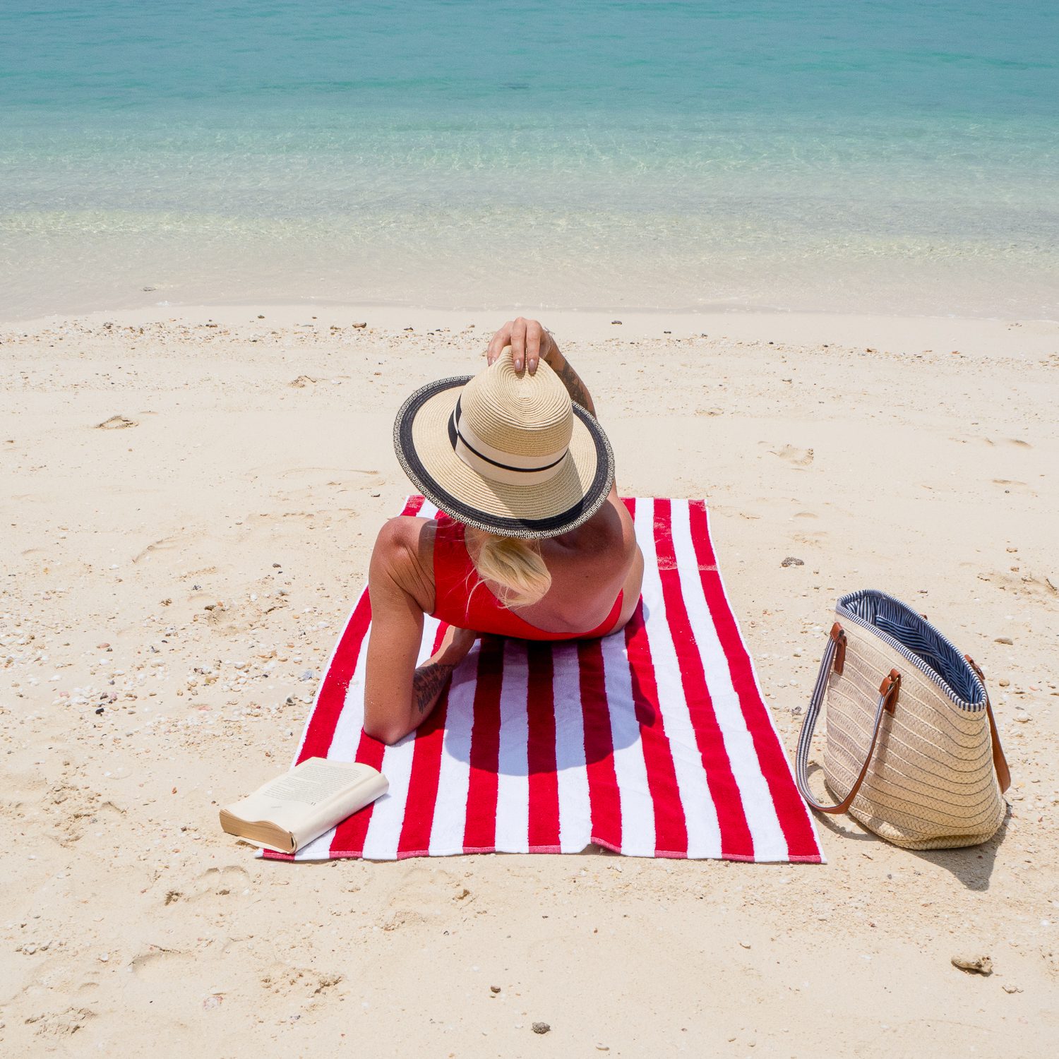 Woman laying on Red Cabana Beach Towel at the beach