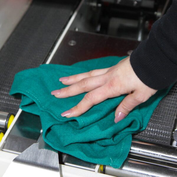 Woman using green Huck Towel to wipe down machinery