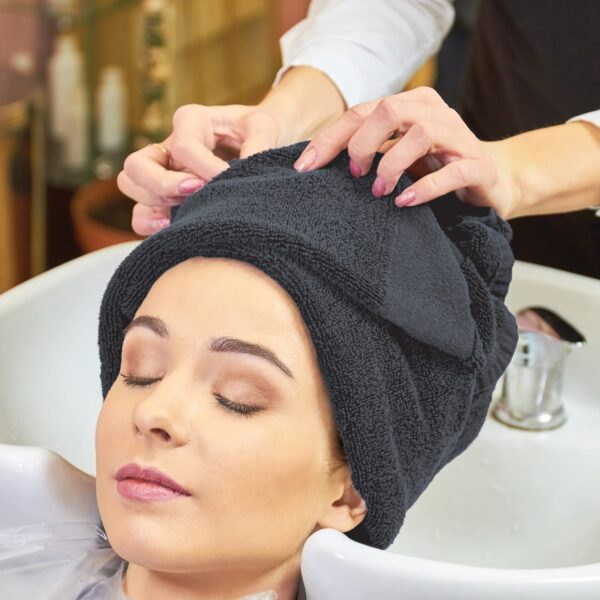 Hair stylist wraps customer's hair in grey salon towel