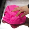 Woman using pink Huck Towel to wipe down surface
