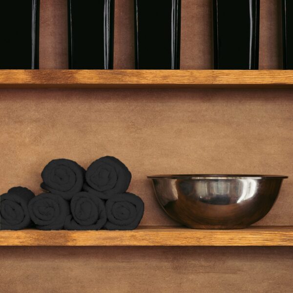 Black rolled up towels on shelf