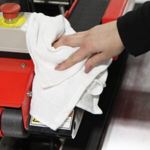 Woman using white Huck Towel to wipe down machinery