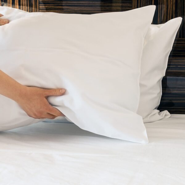 Housekeeping holding white linen pillow