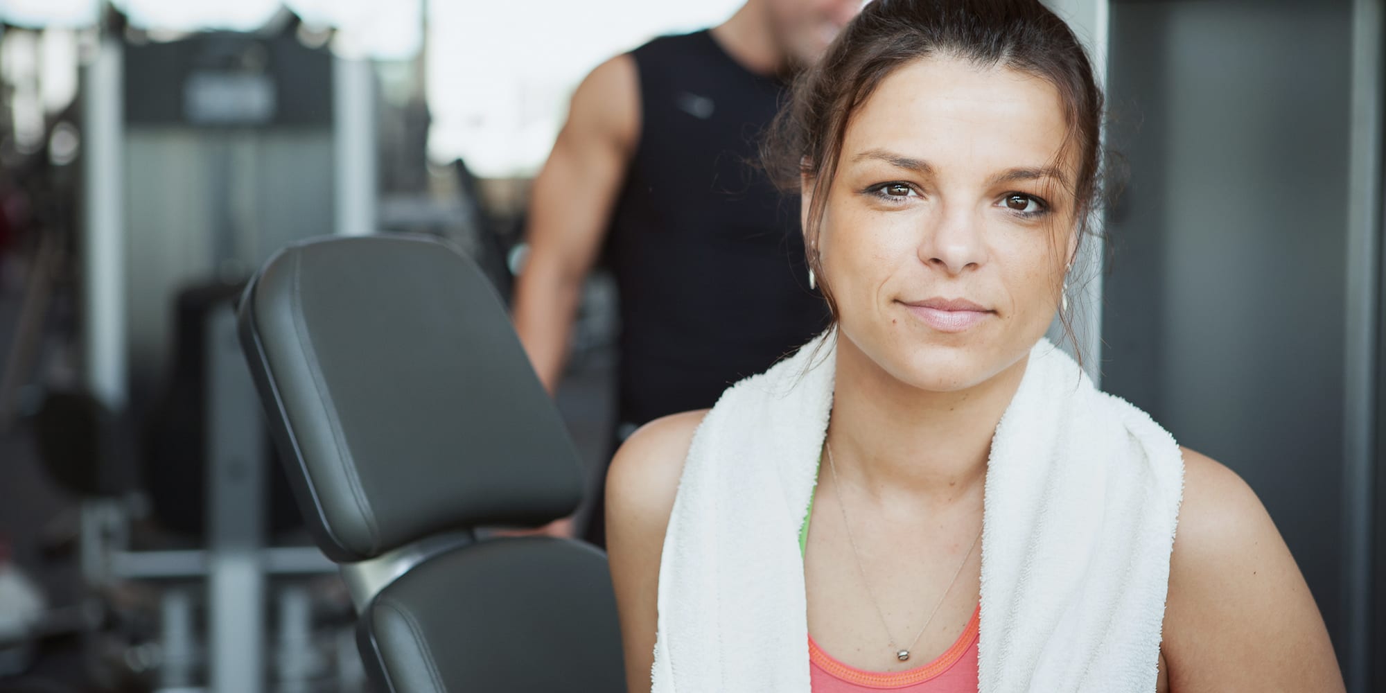 Woman at gym with Monarch Towel draped over her neck