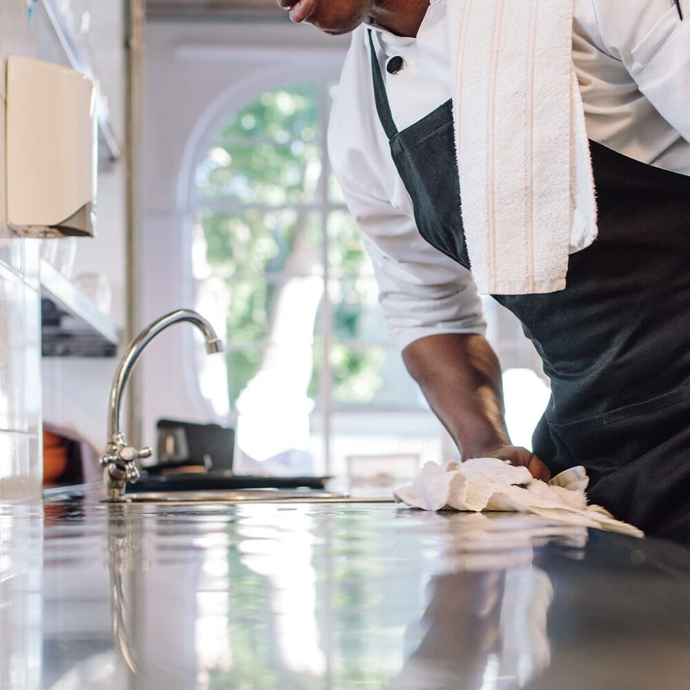 Waiter wiping down counter with Eclipse Irregular Bar Mop