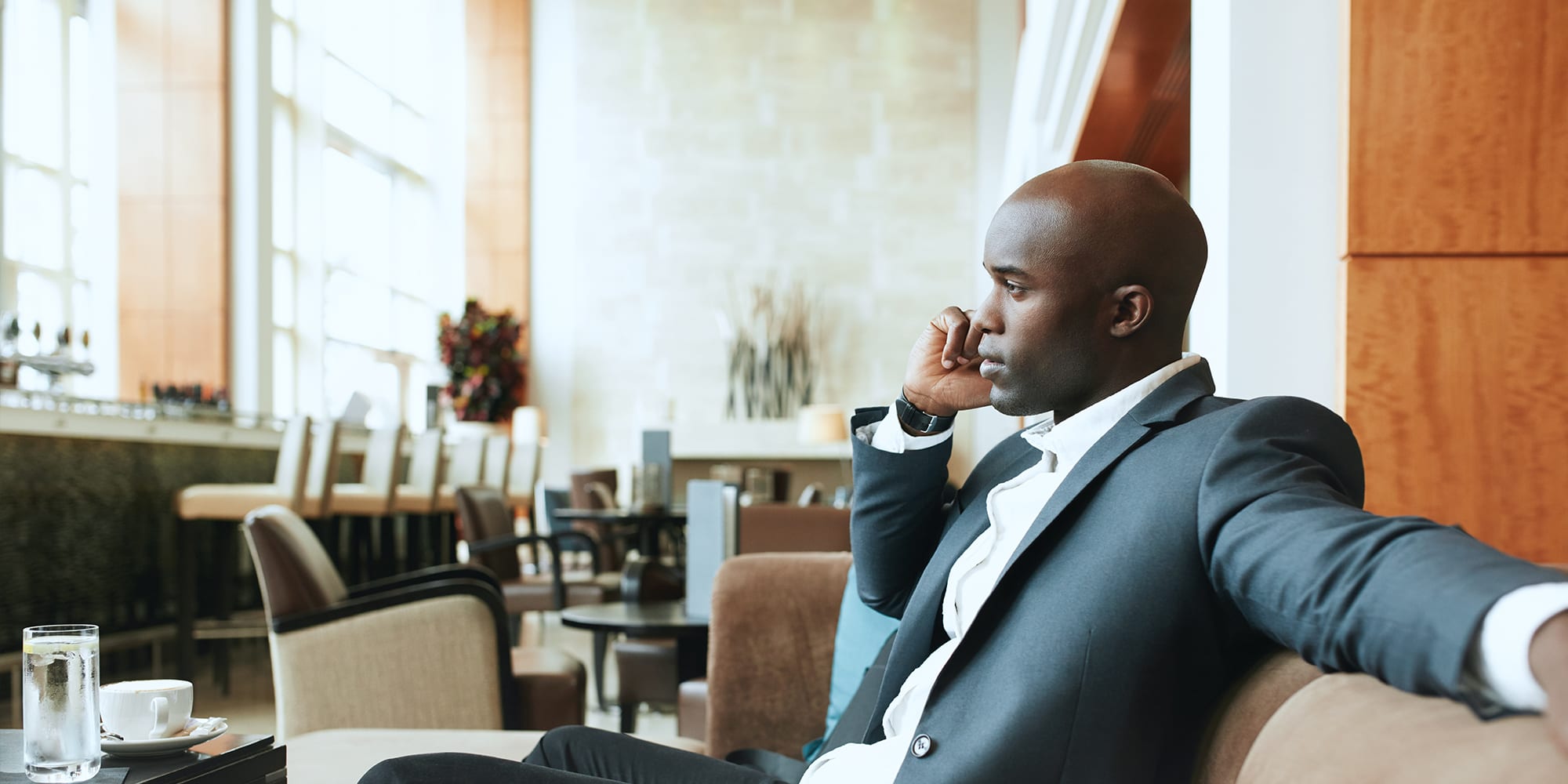 Young man in a suit on the phone at a restaurant