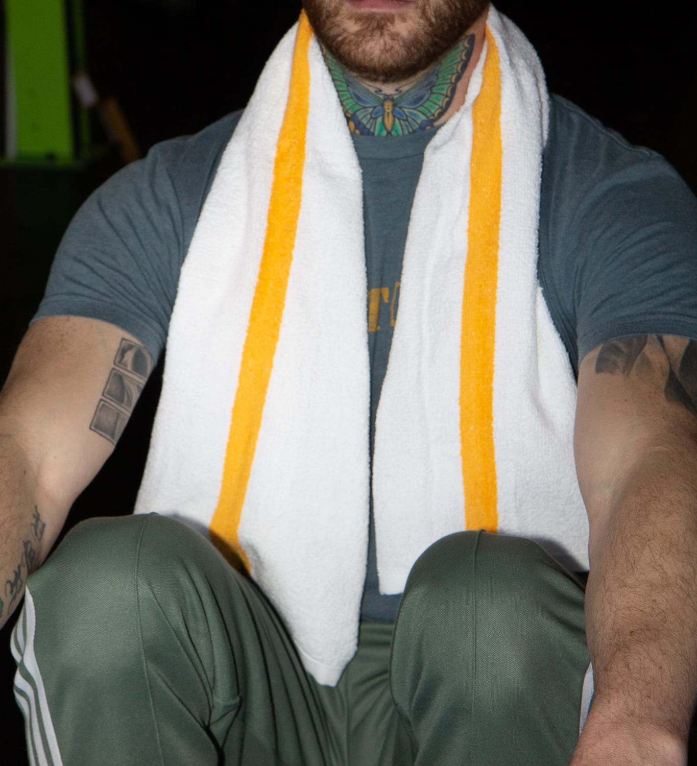 Man with White Gym Towel with Gold Stripe around shoulder