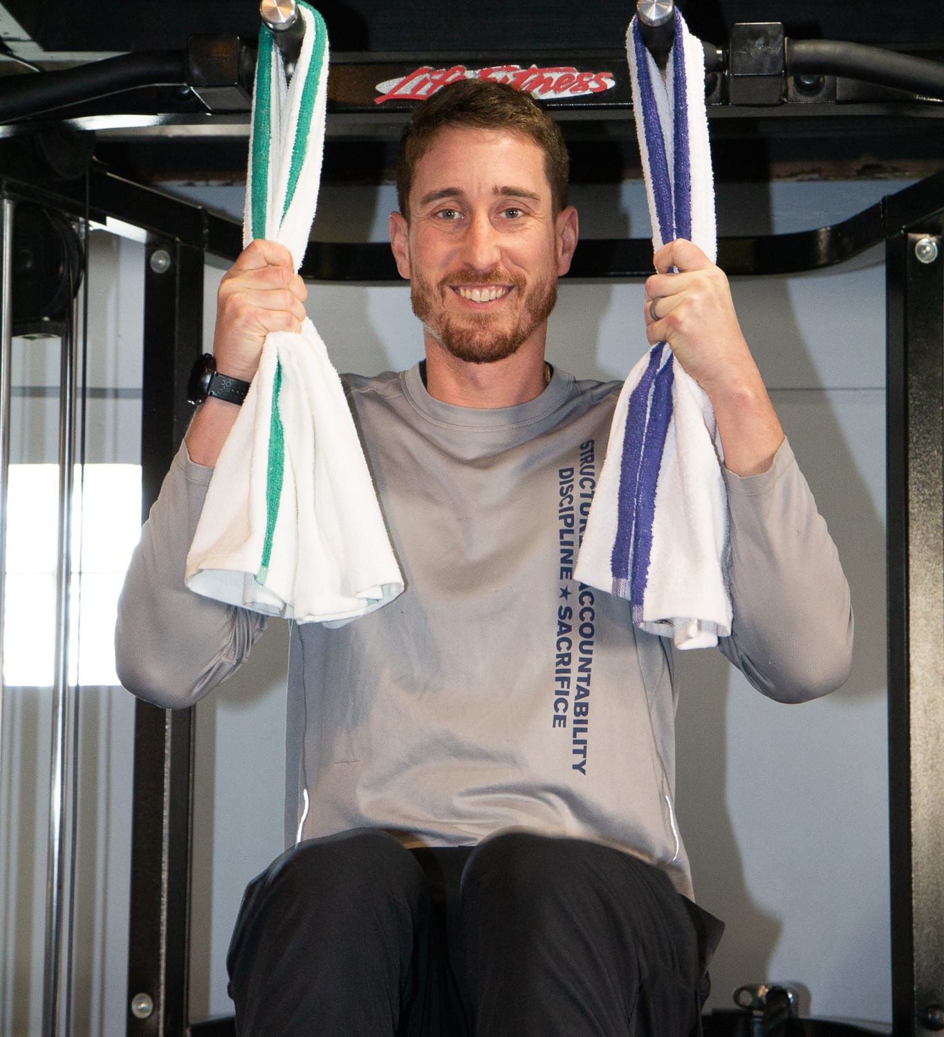 Man doing pull-ups with White Gym Towels with Green and Blue Stipe