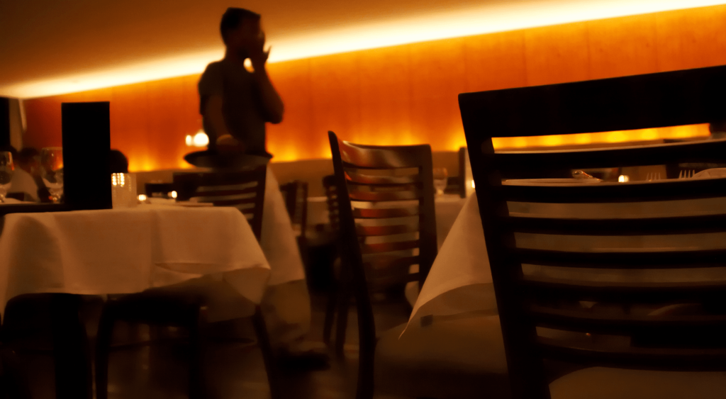 Waiter wearing White Bistro Apron walking around restaurant