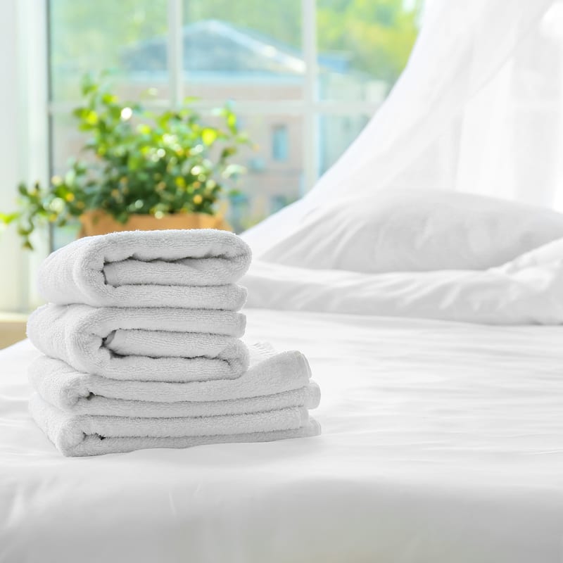 Towels folded and stacked placed on bed